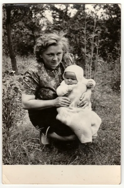 Vintage foto mostra jovem mulher berços bebê . — Fotografia de Stock