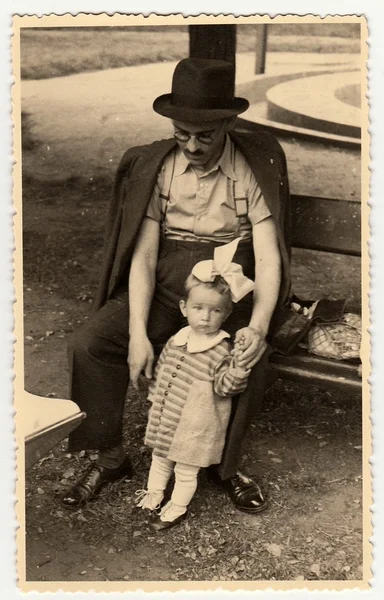 Una foto de la vendimia muestra a la niña y al padre. Niño muestra cara triste . — Foto de Stock