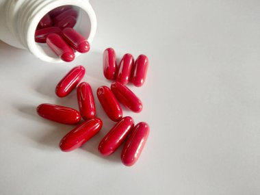 Kırmızı haplar, kırmızı vitamin hapları. Sıcak beyaz, temiz bir görünüş. B vitamini..