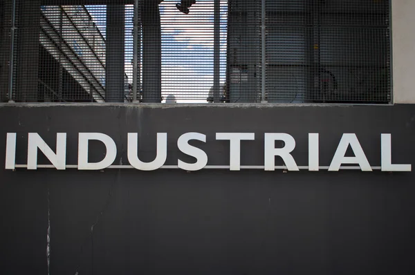 Wort industriell in einer Wand — Stockfoto