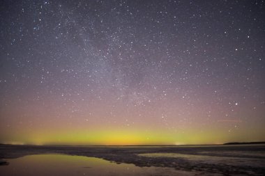 Gölün ve tepelerin üzerinde kuzey ışıkları. Gece Aurora Kuzeyde gökyüzünde.