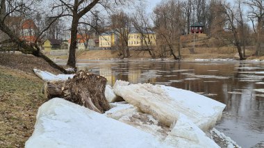 Nehir kıyısında, güneşli havada, orman manzaralı buz parçaları. Mavi gökyüzü