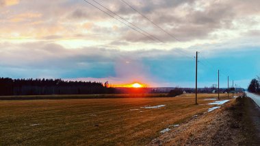 Yağmurdan sonra renkli günbatımı kümülüs bulutlarının altındaki tarımsal alan, altın güneş ışığı. Dramatik bulut manzarası. Idyllic kırsal alan. Resimli panoramik manzara. Bahar manzarası