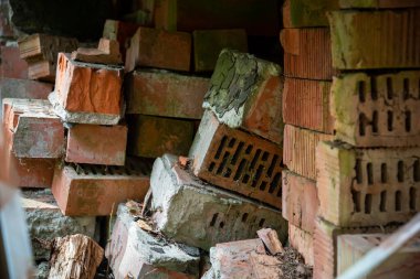 Bir yığın turuncu tuğla. Turuncu tuğlalar yığılmış. Bazı tuğlalar kırılmış. Makro