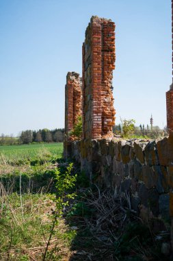 Güneşli bir yaz gününde, çöken taştan bir binanın duvarlarının kalıntıları. Mavi gökyüzü..