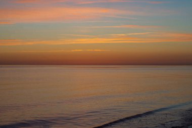 Bulutlu bir gün batımı ile güzel bir gökyüzü. Yağmur bulutlarıyla turuncu ve kırmızı gün batımı