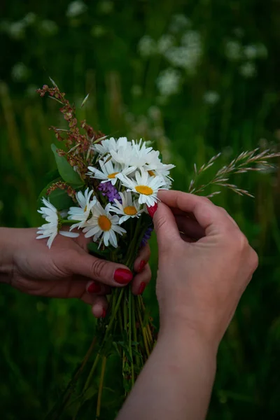 Making a Festive flower wreath, circlet of flowers, festival coronet of flowers on a bright sunny afternoon. Preparing for Midsummer night fest, or bachelorette party idea. How to Make a Flower Crown