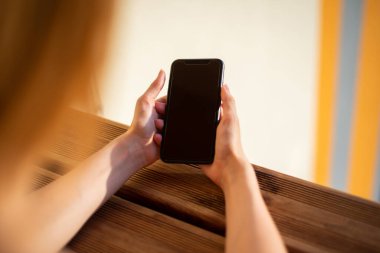 Boş siyah ekranlı cep telefonu kullanan kadın, uygulama tasarımınız için model.
