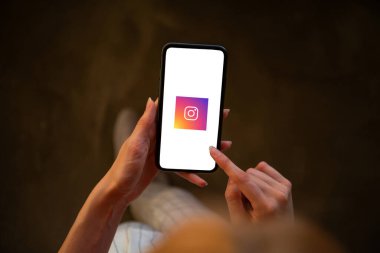 Riga, Letonya - 3 Temmuz 2021: Ekranda Instagram logosu olan cep telefonu tutan kadın