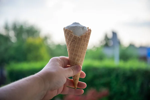 Delicious classic ice cream in a woman's hands. Natural homemade closeup. Sweet dessert for summer. Refreshes in hot weather. Healthy eating, organic food. Take away the traditional product