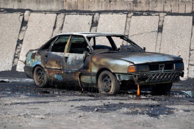 Terk edilmiş ve yanmış bir araba. Terk edilmiş bir araba sessiz bir köy yolunun kenarına bırakılmış..