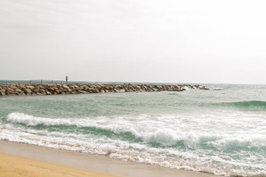 Akdeniz, kumlu sahil ve iskeleli taban.