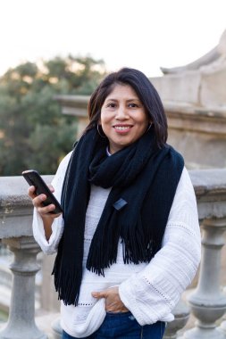 Telefonda beyaz kazak ve atkıyla konuşan bir kız. Teknoloji konsepti. 