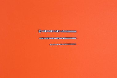 Tatbikat. İnşaat matkapları. İnşaat ve onarım. İnşaat aleti. Turuncu arkaplan.