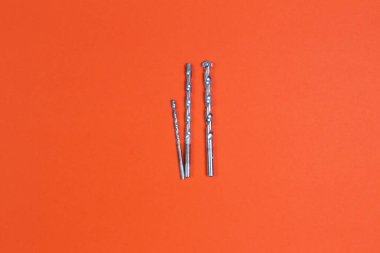 Tatbikat. İnşaat matkapları. İnşaat ve onarım. İnşaat aleti. Turuncu arkaplan.