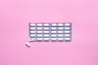 Pembe arka planda beyaz haplar, tedavi. Minimalizm