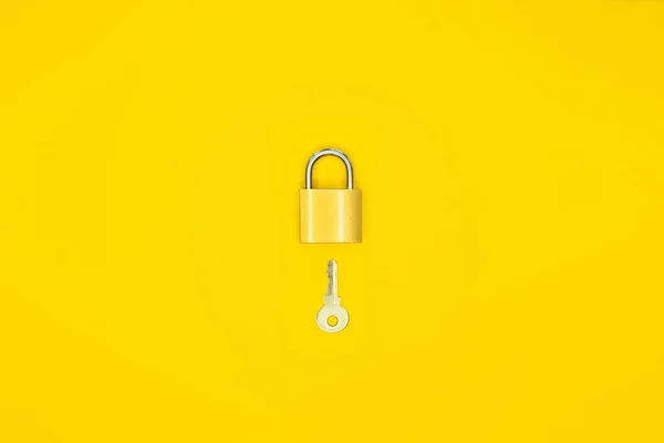 Lock and key on a yellow background.