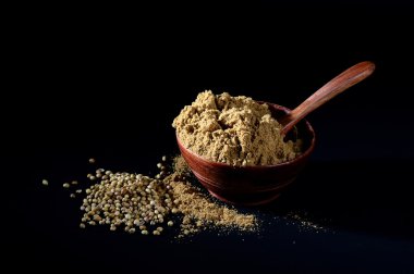 Kişniş tohumu ve kil kapta kişniş tozu veya koyu arkaplanda kase.