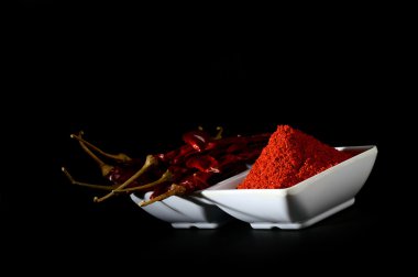 kırmızı beyaz plaka, siyah arka plan üzerine kurutulmuş biber soğuk soğuk toz