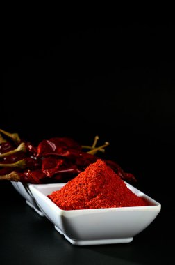 kırmızı beyaz plaka, siyah arka plan üzerine kurutulmuş biber soğuk soğuk toz