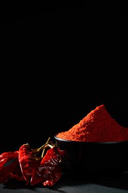 soğuk, kuru kırmızı biber siyah arka plan üzerine siyah kase soğuk toz