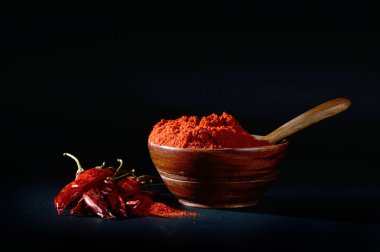 soğuk, kuru kırmızı biber siyah arka plan üzerine ahşap kase soğuk toz