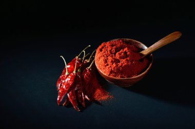 soğuk, kuru kırmızı biber siyah arka plan üzerine ahşap kase soğuk toz