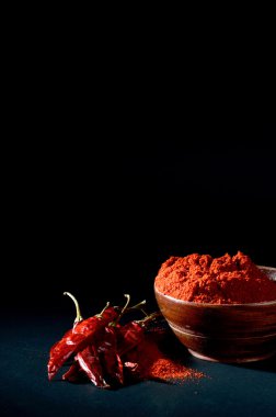 soğuk, kuru kırmızı biber siyah arka plan üzerine ahşap kase soğuk toz