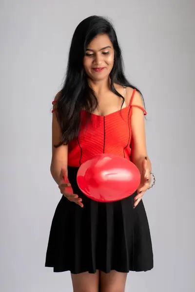 穿着华丽红黑相间的衣服 头戴心形气球 快乐而可爱的女孩 — 图库照片