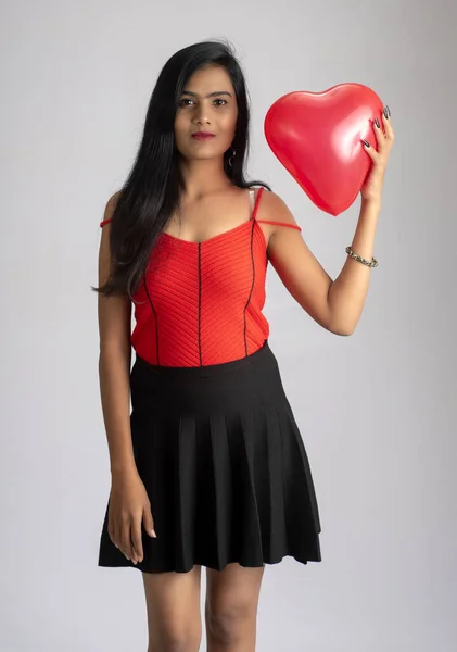 Süslü Kırmızı Siyah Elbiseli Neşeli Kız Kalp Şeklinde Balonla Poz — Stok fotoğraf
