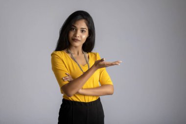 Mutlu gülümseyen bir yüzle elinde bir şey tutan ve sunan başarılı, neşeli bir genç kızın portresi.