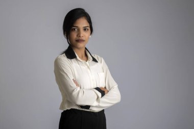 Gri arka planda poz veren genç bir kızın portresi.