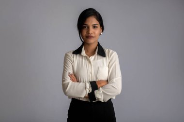 Gri arka planda poz veren genç bir kızın portresi.