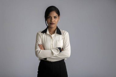 Gri arka planda poz veren genç bir kızın portresi.