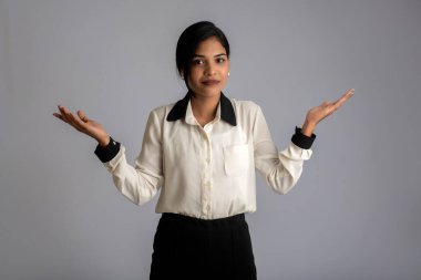 Güzel kız elinde mutlu bir gülümsemeyle bir şey tutuyor ve sunuyor..