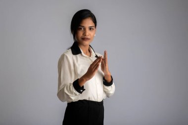 Gri arka planda dur işareti gösteren güzel bir kızın portresi