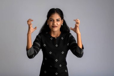 Gri arka planda poz veren genç bir kızın portresi