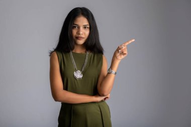 Mutlu gülümseyen bir yüzle elinde bir şey tutan ve sunan başarılı, neşeli bir genç kızın portresi.