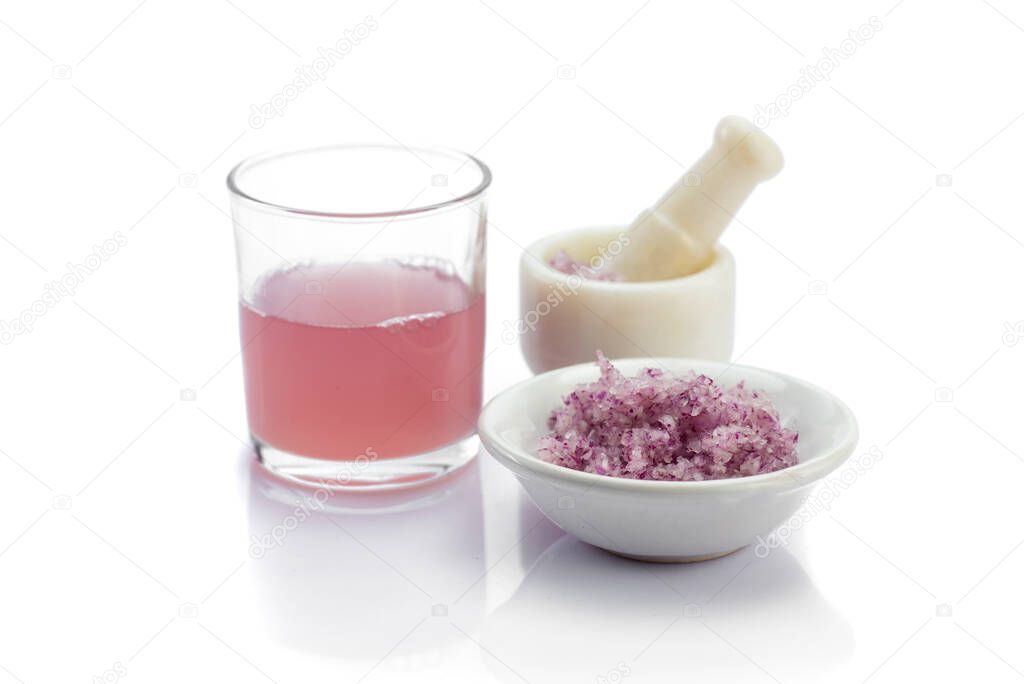 Medicinal Onion juice/syrup in a glass with fresh red onions and paste in Mortar and pestle
