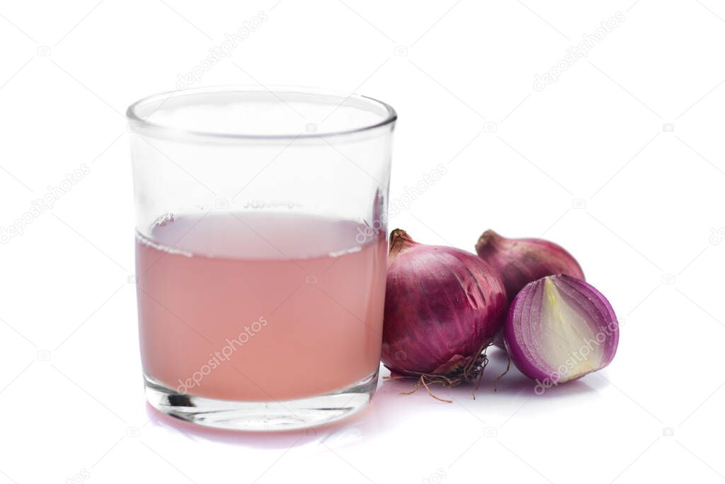 Medicinal Onion juice/syrup in a glass with fresh red onions on a white background