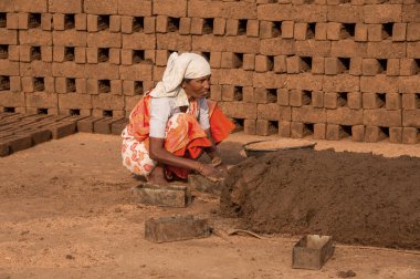 AMRAVATI, MAHARASHTRA - 24 Mayıs 2018: Kil veya çamur üzerinde işlem yapan ve tuğla fırını, fabrikası veya tarlasında geleneksel tuğlaları elle yapan tanımlanamayan Hintli işçiler.