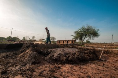 AMRAVATI, MAHARASHTRA - 24 Mayıs 2018: Fabrikada veya tarlada elle kil tuğla yapan tanımlanamayan Hintli işçiler.