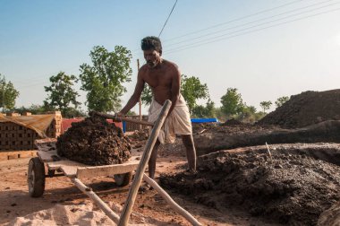 AMRAVATI, MAHARASHTRA - 24 Mayıs 2018: Fabrikada veya tarlada elle kil tuğla yapan tanımlanamayan Hintli işçiler.