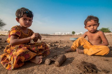 AMRAVATI, MAHARASHTRA - 24 Mayıs 2018: Kimliği belirsiz Hintli işçi çocukları tuğla ocağında veya fabrikada geleneksel tuğla yapımına yardım ediyorlar.