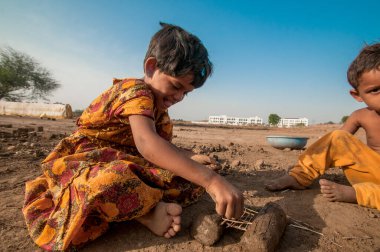 AMRAVATI, MAHARASHTRA - 24 Mayıs 2018: Kimliği belirsiz Hintli işçi çocukları tuğla ocağında veya fabrikada geleneksel tuğla yapımına yardım ediyorlar.
