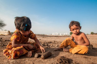 AMRAVATI, MAHARASHTRA - 24 Mayıs 2018: Kimliği belirsiz Hintli işçi çocukları tuğla ocağında veya fabrikada geleneksel tuğla yapımına yardım ediyorlar.+