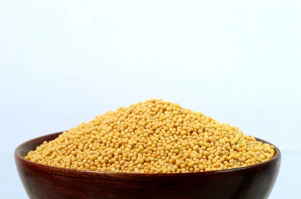 Yellow mustard seeds in wooden bowl — Stock Photo, Image