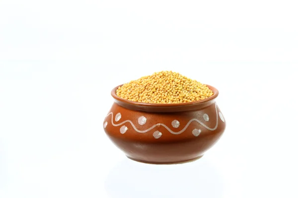 Žlutá hořčičná semena v hliněné nádobě — Stock fotografie