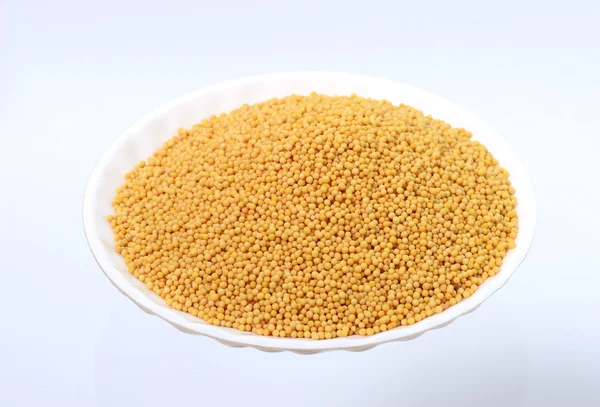 Yellow mustard seeds in plate — Stock Photo, Image