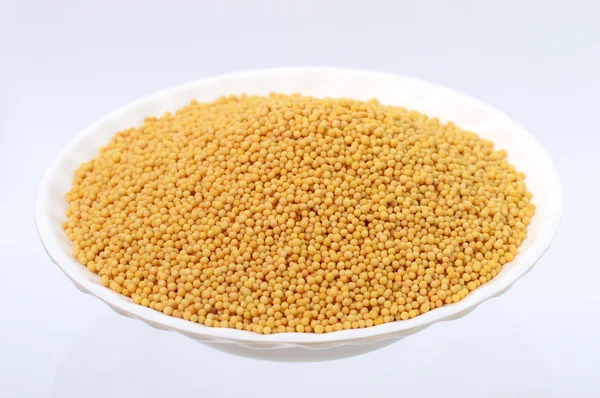 Yellow mustard seeds in plate — Stock Photo, Image